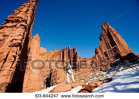 Stock Photo - Female hiker admires the beautiful sandstone spires from trail at Fisher Towers outside Moab, Utah, USA. Fotosearch