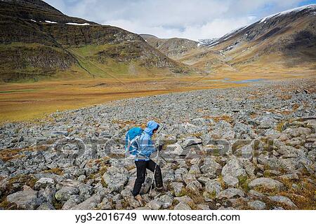 Female hiker hikes over rocky terrain in Tj? ktjavagge on Kungsleden trail, Lappland, Sweden. View Large Photo Image Stock Photo - Female hiker hikes over rocky terrain in Tj? ktjavagge on Kungsleden trail, Lappland, Sweden.. Fotosearch