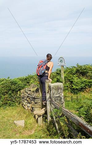 Stock Image - Female hiker near Loftus Alum Quarries on The Cleveland Way national trail coastal footpath near Staithes in North Yorkshire, England, United Kingdom. Fotosearch