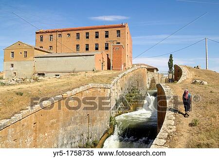 Female hiker near old flour mill nearcanal lock gates at El Serron Canal de Castilla, Palencia, province, Castilla-Leon, Spain A footpath/cycle track runs alongside nearly the whole length of the canal View Large Photo Image Stock Photography - Female hiker near old flour mill nearcanal lock gates at El Serron Canal de Castilla, Palencia, province, Castilla-Leon, Spain A footpath/cycle track runs alongside nearly the whole length of the canal. Fotosearch