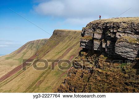 Picture - Female hiker on Carmarthen Fans - Bannau Sir Gaer with Picws Du in distance, Black Mountain, Brecon Beacons national park, Wales.. Fotosearch