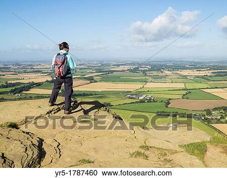 Stock Image - Female hiker on Roseberry Topping 320m on The Cleveland Way National Trail North York Moors National Park near Great Ayton, North Yorkshire, England, United Kingdom. Fotosearch