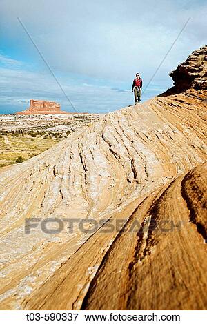 Female hiker on sandstone slickrock with Merrimac Butte in the background near Canyonlands National Park, Utah, USA. View Large Photo Image Stock Photo - Female hiker on sandstone slickrock with Merrimac Butte in the background near Canyonlands National Park, Utah, USA.. Fotosearch
