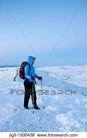 Stock Photo - Female hiker on summit of Pen Y Fan in winter, Brecon Beacons national park, Wales. Fotosearch