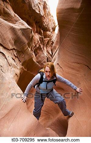 Female hiker scrambles through a narrow section of Little Wildhorse Slot Canyon in the San Rafael Swell, Utah, USA View Large Photo Image Stock Photography - Female hiker scrambles through a narrow section of Little Wildhorse Slot Canyon in the San Rafael Swell, Utah, USA. Fotosearch