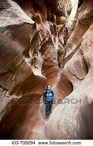 Female hiker stands in sandstone chamber in Little Wildhorse Slot Canyon, San Rafael Swell, Utah, USA View Large Photo Image Picture - Female hiker stands in sandstone chamber in Little Wildhorse Slot Canyon, San Rafael Swell, Utah, USA. Fotosearch