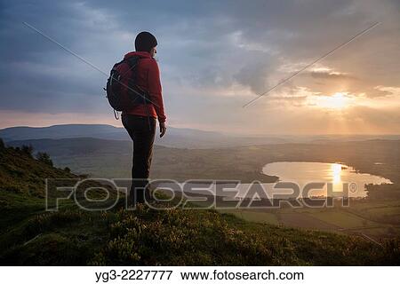 Female hiker takes in view of Llangorse lake from Mynydd Llangorse, Brecon Beacons national park, Wales. View Large Photo Image Stock Photo - Female hiker takes in view of Llangorse lake from Mynydd Llangorse, Brecon Beacons national park, Wales.. Fotosearch