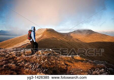 Stock Photography - Female hiker with Corn Du and Pen Y Fan in Background, Brecon Beacons national park, Wales. Fotosearch