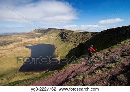 Female hill walker hiking towards Waun Lefrith above Llyn Y Fan Fach, Black Mountain, Brecon Beacons national park, Wales. View Large Photo Image Stock Image - Female hill walker hiking towards Waun Lefrith above Llyn Y Fan Fach, Black Mountain, Brecon Beacons national park, Wales.. Fotosearch