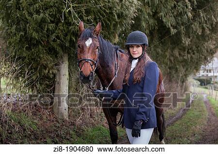 Stock Image - Female horserider and her horse. Fotosearch