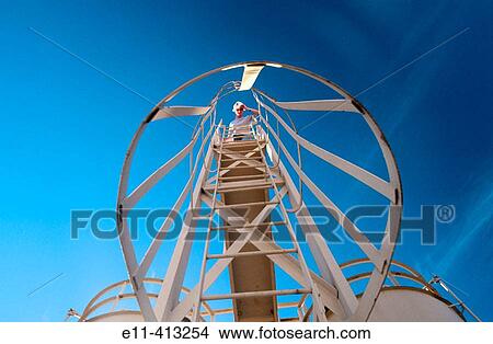 Female industrial worker at top of ladder at power plant View Large Photo Image Picture - Female industrial worker at top of ladder at power plant. Fotosearch