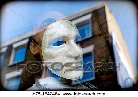 Female mannequin with a mask in shop-window glass with reflections View Large Photo Image Picture - Female mannequin with a mask in shop-window glass with reflections. Fotosearch
