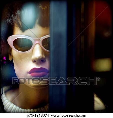 Female mannequin with retro glasses behind glass looking at the camera View Large Photo Image Picture - Female mannequin with retro glasses behind glass looking at the camera. Fotosearch