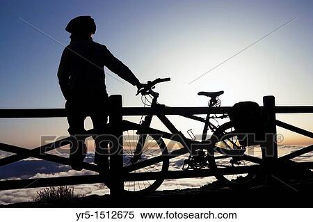 Stock Photography - Female mountinbiker above the clouds at sunrise at Pinos de Galdar, Gran Canaria, Canary Islands, Spain. Fotosearch