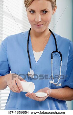 Female Nurse dispensing medicine View Large Photo Image Picture - Female Nurse dispensing medicine. Fotosearch