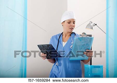 Picture - Female Nurse examining an X-ray. Fotosearch