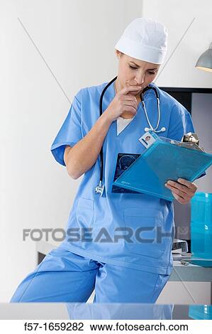 Stock Image - Female Nurse examining an X-ray. Fotosearch