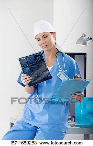 Female Nurse examining an X-ray View Large Photo Image Stock Image - Female Nurse examining an X-ray. Fotosearch