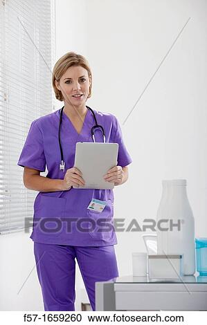 Female Nurse reviewing medical records on a tablet computer View Large Photo Image Stock Image - Female Nurse reviewing medical records on a tablet computer. Fotosearch