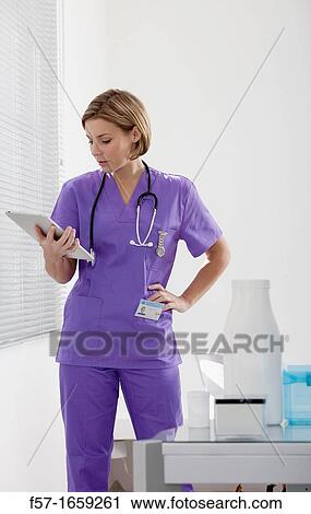Female Nurse reviewing medical records on a tablet computer View Large Photo Image Stock Image - Female Nurse reviewing medical records on a tablet computer. Fotosearch
