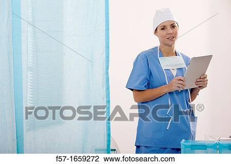Female Nurse reviewing medical records on a tablet computer View Large Photo Image Stock Image - Female Nurse reviewing medical records on a tablet computer. Fotosearch