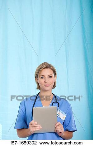 Female Nurse reviewing medical records on a tablet computer View Large Photo Image Stock Image - Female Nurse reviewing medical records on a tablet computer. Fotosearch