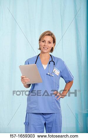 Female Nurse reviewing medical records on a tablet computer View Large Photo Image Stock Image - Female Nurse reviewing medical records on a tablet computer. Fotosearch