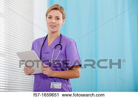Female Nurse reviewing medical records on a tablet computer View Large Photo Image Stock Image - Female Nurse reviewing medical records on a tablet computer. Fotosearch
