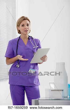 Female Nurse reviewing medical records on a tablet computer View Large Photo Image Stock Photo - Female Nurse reviewing medical records on a tablet computer. Fotosearch