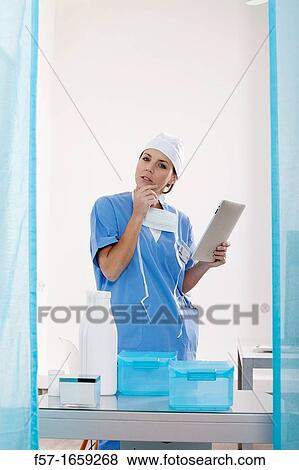 Female Nurse reviewing medical records on a tablet computer View Large Photo Image Stock Photo - Female Nurse reviewing medical records on a tablet computer. Fotosearch
