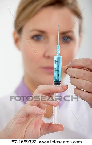 Stock Image - Female Nurse with a syringe. Fotosearch