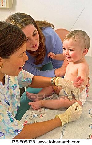 Female pediatric nurse giving injection into thigh of infant, with mother, comforting and looking on. View Large Photo Image Stock Photo - Female pediatric nurse giving injection into thigh of infant, with mother, comforting and looking on.. Fotosearch