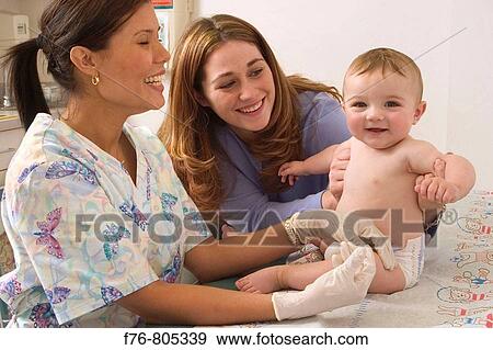 Female pediatric nurse giving injection into thigh of infant, with mother, comforting and looking on. View Large Photo Image Stock Photo - Female pediatric nurse giving injection into thigh of infant, with mother, comforting and looking on.. Fotosearch