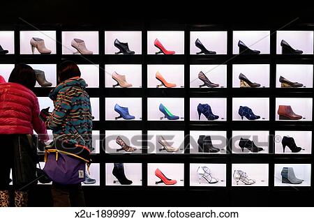 Female shoppers examining a shop display of brightly coloured shoes View Large Photo Image Stock Photo - Female shoppers examining a shop display of brightly coloured shoes. Fotosearch