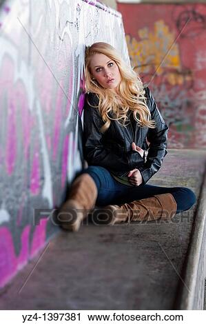 Stock Image - Female student sitting with graffiti. Fotosearch