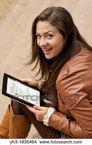 Female student studying university course from her ipad using iTunes U application View Large Photo Image Picture - Female student studying university course from her ipad using iTunes U application. Fotosearch