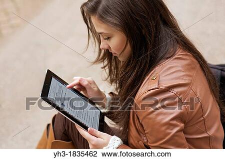 Female student studying university course from her ipad using iTunes U application View Large Photo Image Stock Image - Female student studying university course from her ipad using iTunes U application. Fotosearch