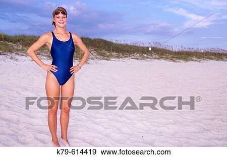Female swimmer standing on the sand at the beach. View Large Photo Image Stock Photo - Female swimmer standing on the sand at the beach.. Fotosearch