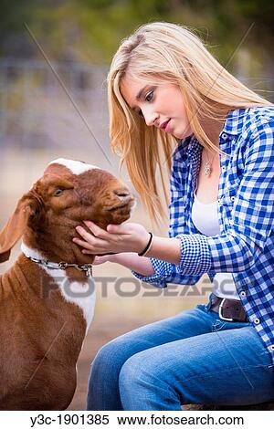 Female teenager petting a goat on a livestock farm in Texas. View Large Photo Image Stock Photography - Female teenager petting a goat on a livestock farm in Texas.. Fotosearch