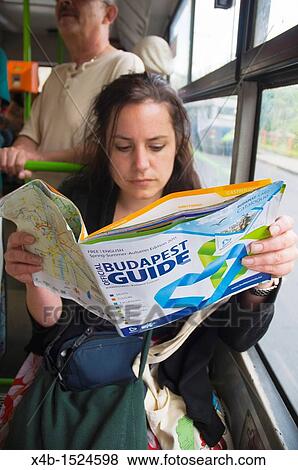 Stock Photo - Female tourist reading Budapest Guide information magazine Budapest Hungary Europe. Fotosearch