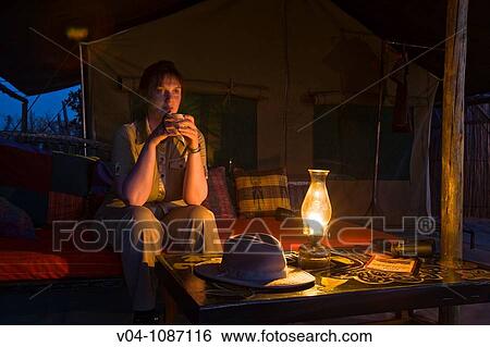 Female tourist sitting in front of a safari tent in Botswana, Africa View Large Photo Image Stock Photograph - Female tourist sitting in front of a safari tent in Botswana, Africa. Fotosearch