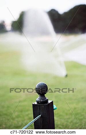 Fence post with sprinklers on golf course View Large Photo Image Stock Image - Fence post with sprinklers on golf course. Fotosearch