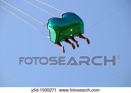 Fetes de Geneve, Days od Geneva, Switzerland, two pairs of legs hanging from seat of carousel View Large Photo Image Stock Image - Fetes de Geneve, Days od Geneva, Switzerland, two pairs of legs hanging from seat of carousel. Fotosearch