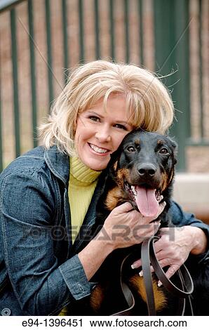 Fifty year old blond woman hugging a Doberman Pinscher on a stairway in a park. View Large Photo Image Stock Image - Fifty year old blond woman hugging a Doberman Pinscher on a stairway in a park.. Fotosearch