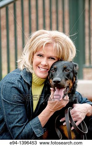 Fifty year old blond woman hugging a Doberman Pinscher on a stairway in a park. View Large Photo Image Stock Image - Fifty year old blond woman hugging a Doberman Pinscher on a stairway in a park.. Fotosearch