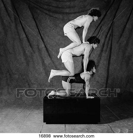 Stock Photo - Filipino woman holding up twin male adults in acrobatic stunt. Fotosearch