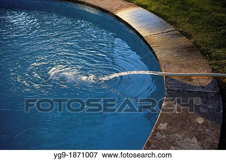Filling a pool with a hosepipe View Large Photo Image Stock Photo - Filling a pool with a hosepipe. Fotosearch