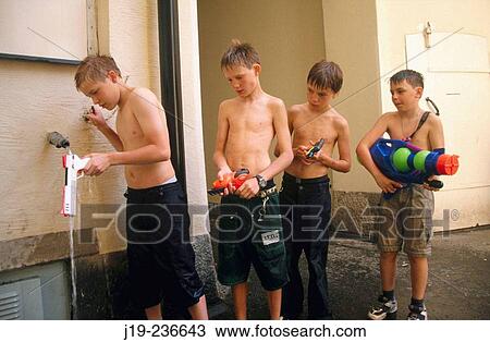 Stock Image - Filling up water guns. Fotosearch