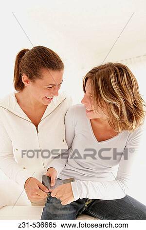 Stock Photography - Fiona, Carla, Seated, Looking each other, Paper. Fotosearch