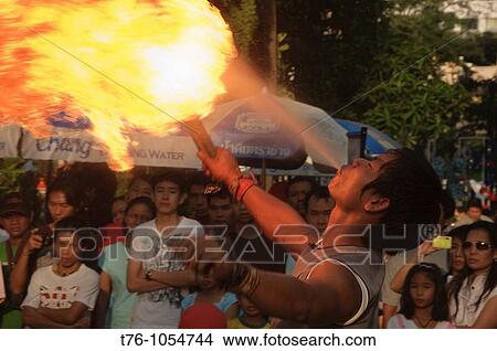 Picture - fire eater performing at the Silom Street Festival in Bangkok Thailand. Fotosearch